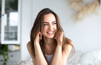 woman sitting in her bed smiling