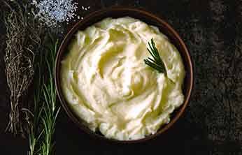 Mashed potatoes in a bowl with a garnish