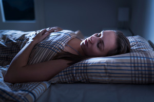 Woman in bed with sleep apnea at night