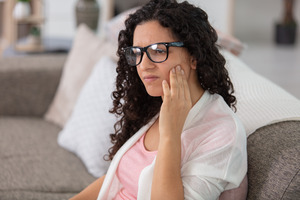 Concerned woman rubbing her jaw