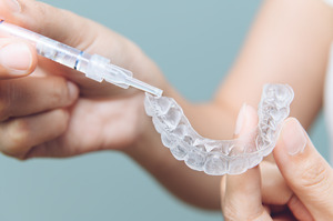 Filling a tray with whitening gel